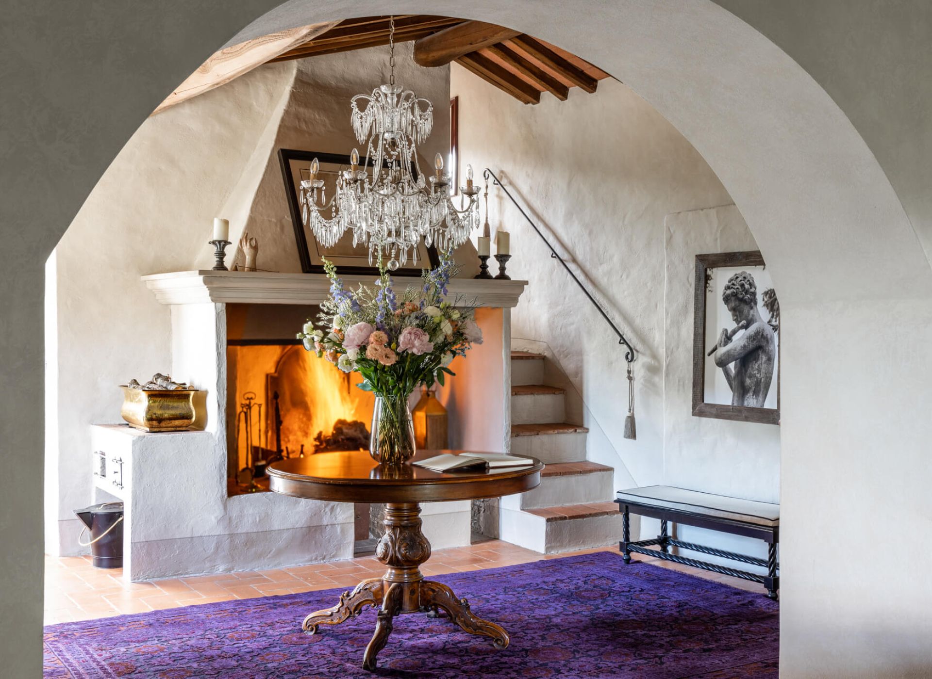 Arched Tuscan interior with fireplace, chandelier and terracotta floors